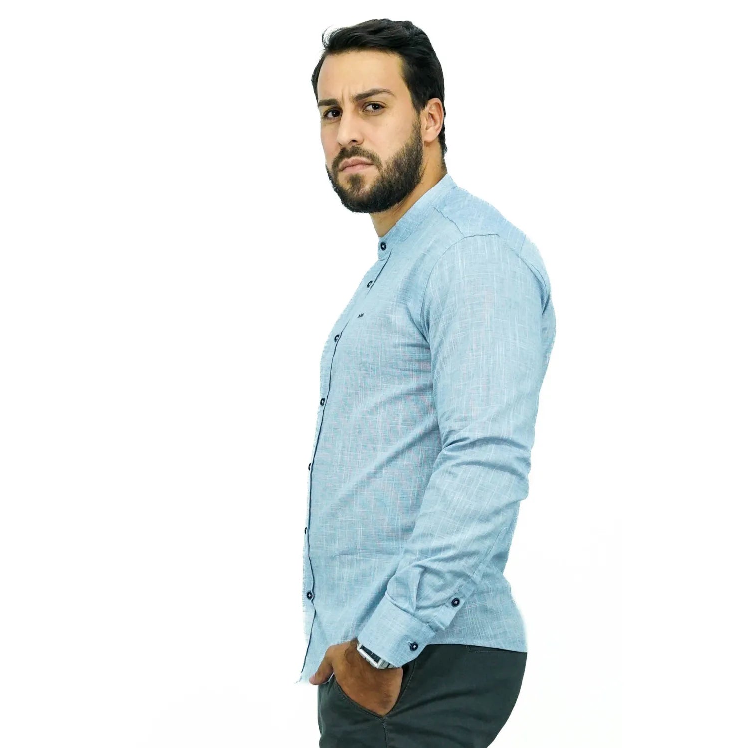 Camisa social masculina gola padre manga longa 100% algodão, estilo linho, na cor azul. Foto de um modelo vestindo a camisa social Absinto Men, com botões pretos e logo da marca