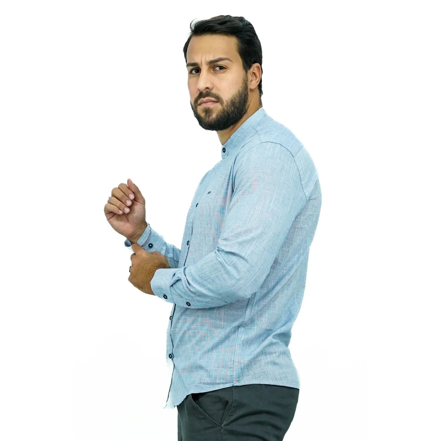 Camisa social masculina gola padre manga longa 100% algodão, estilo linho, na cor azul. Foto de um modelo vestindo a camisa social Absinto Men, com botões pretos e logo da marca