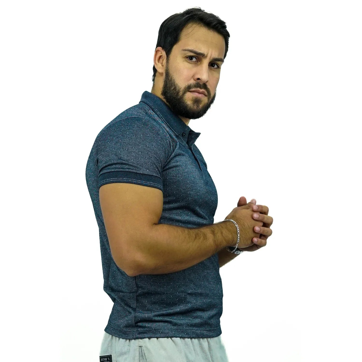 Modelo vestindo camisa gola polo maquinetada, de algodão e poliéster, na cor cinza da marca Absinto Men.