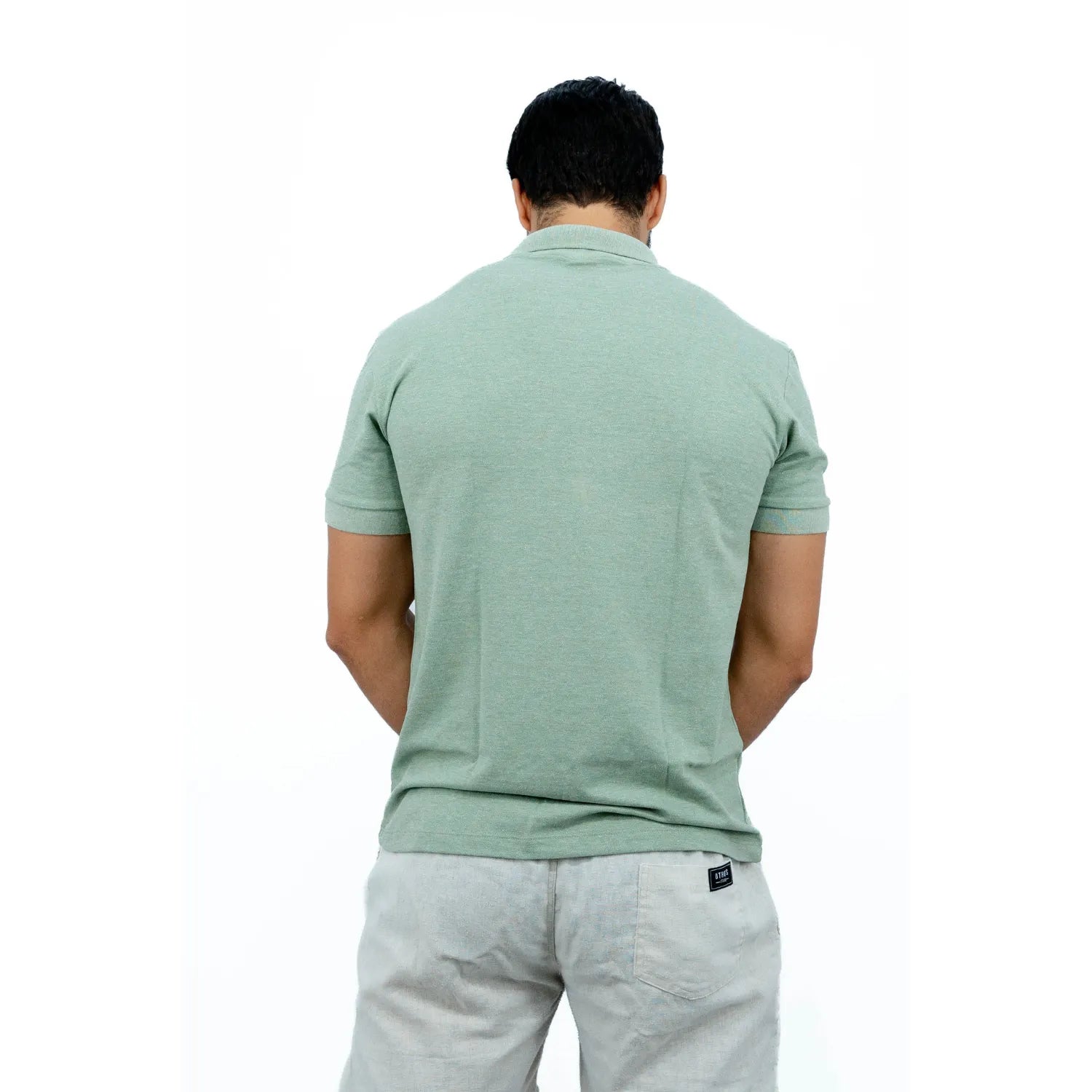 Modelo usando camisa gola polo de algodão e poliéster, lisa, na cor verde da Absinto Men.