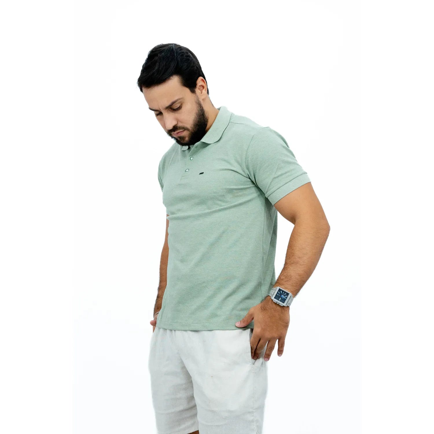 Modelo usando camisa gola polo de algodão e poliéster, lisa, na cor verde da Absinto Men.