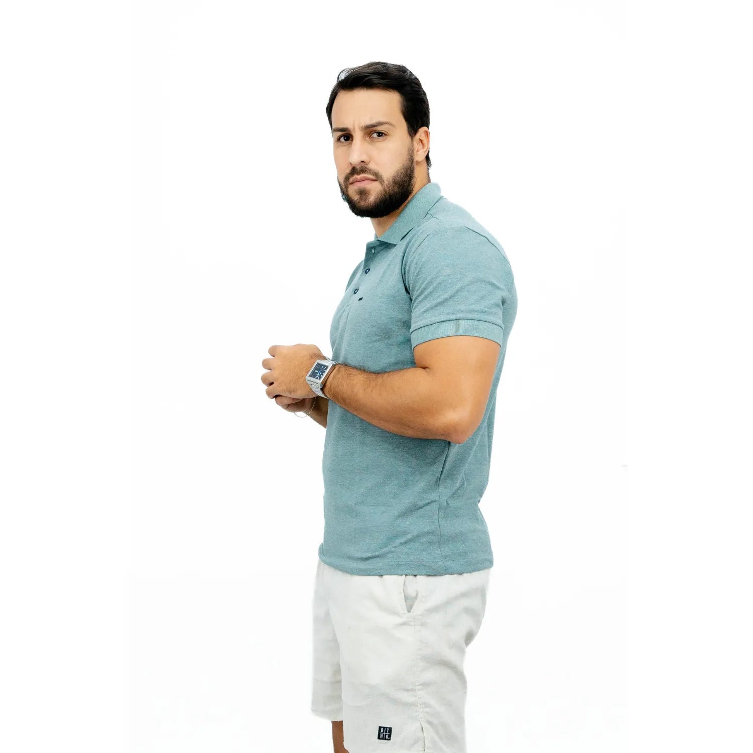 Modelo usando camisa gola polo de algodão e poliéster, lisa, na cor verde lodo da Absinto Men.