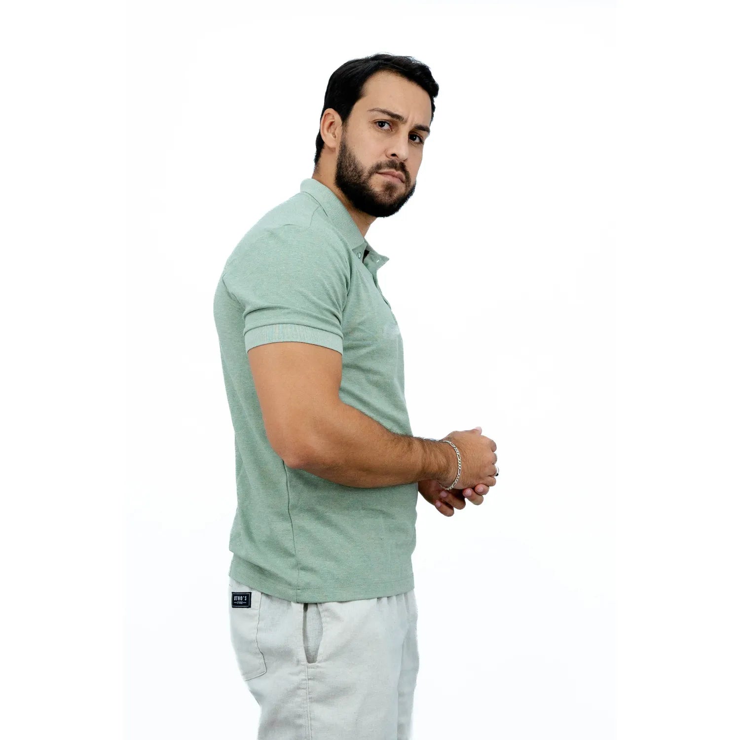 Modelo usando camisa gola polo de algodão e poliéster, lisa, na cor verde da Absinto Men.