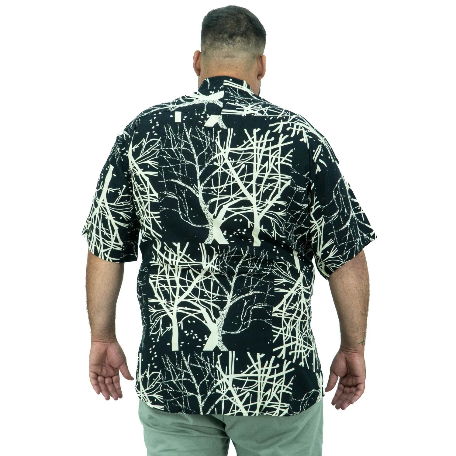 Modelo usando camisa social de viscose plus size de manga curta e com estampa de galhos na cor preta da Absinto Men.