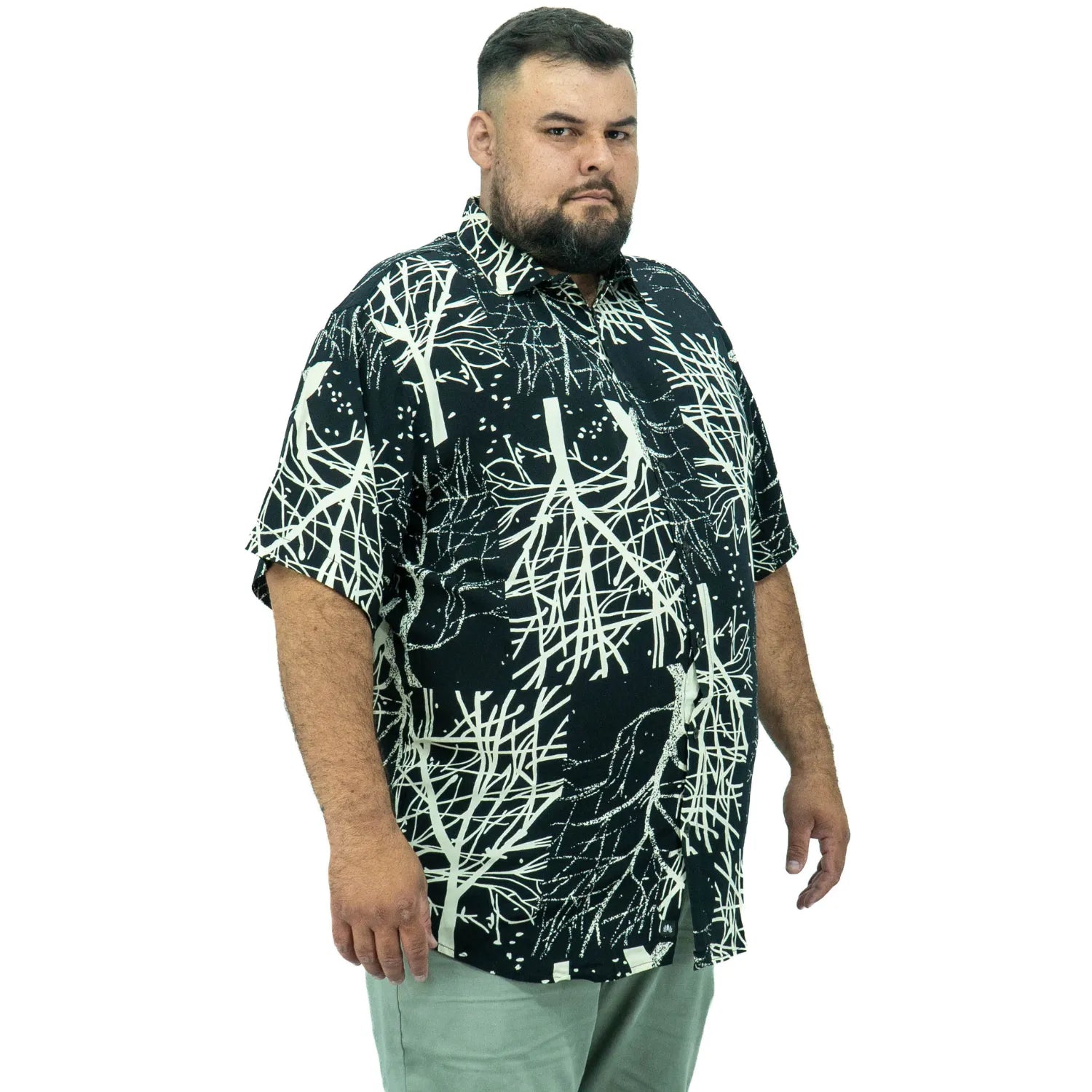 Modelo usando camisa social de viscose plus size de manga curta e com estampa de galhos na cor preta da Absinto Men.