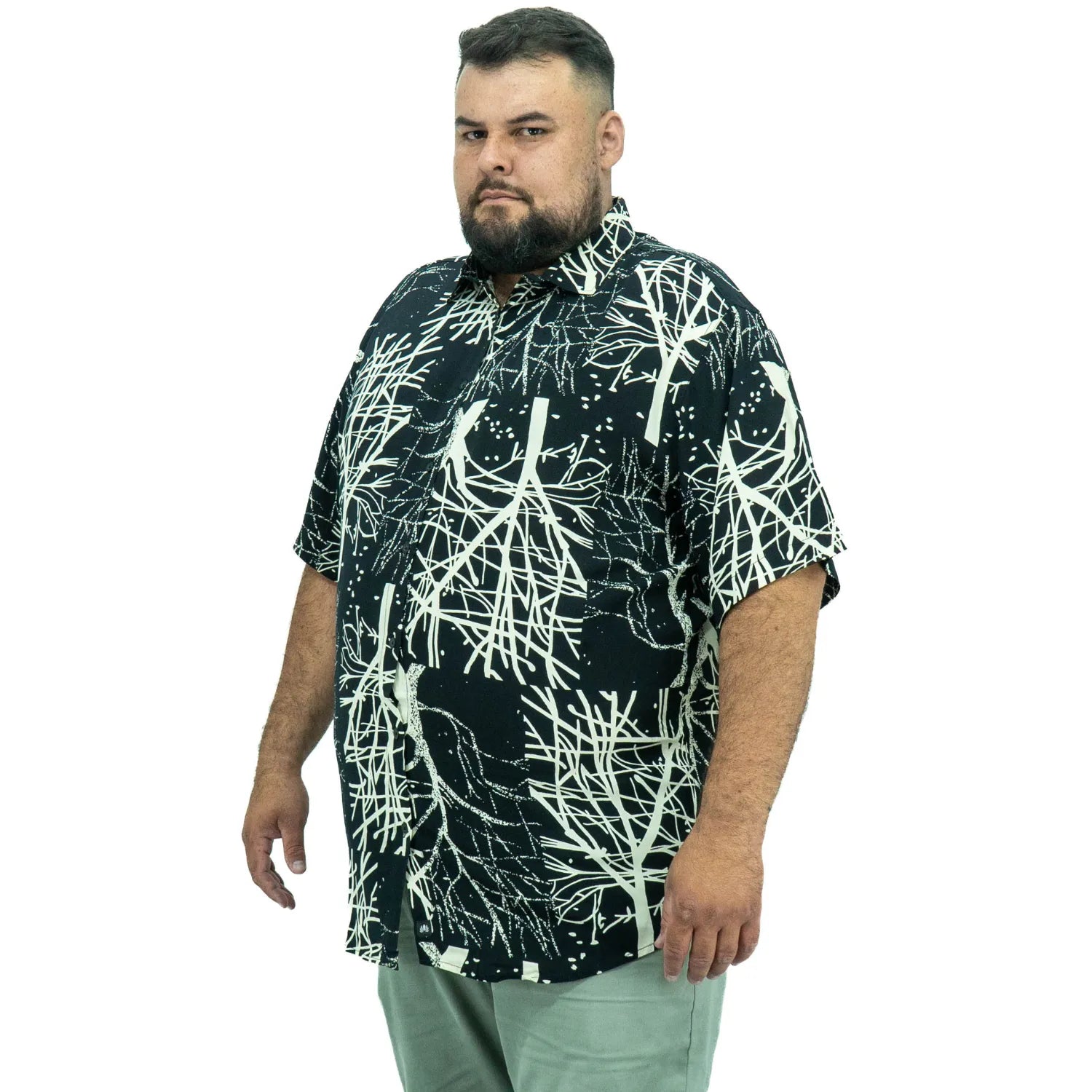 Modelo usando camisa social de viscose plus size de manga curta e com estampa de galhos na cor preta da Absinto Men.