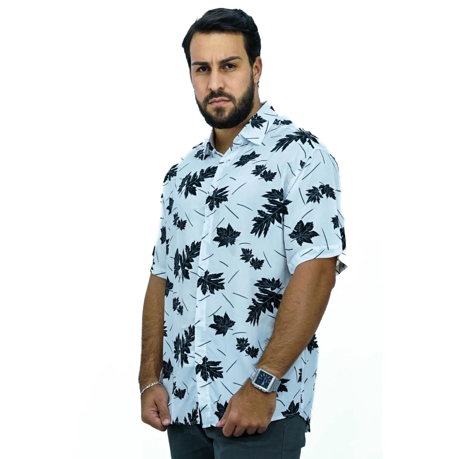Modelo usando camisa social de viscose, de manga curta e com estampa de folhagem, na cor preta.