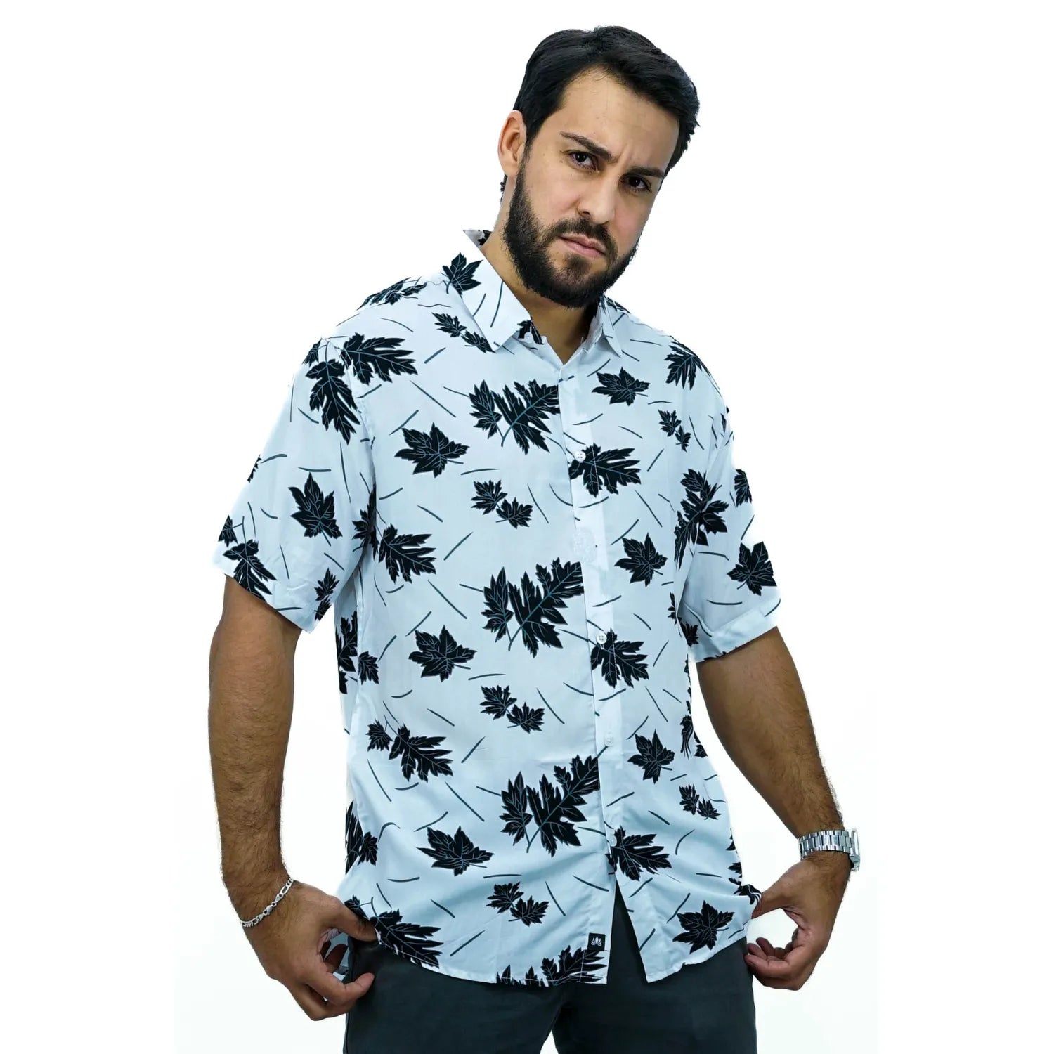 Modelo usando camisa social de viscose, de manga curta e com estampa de folhagem, na cor preta.