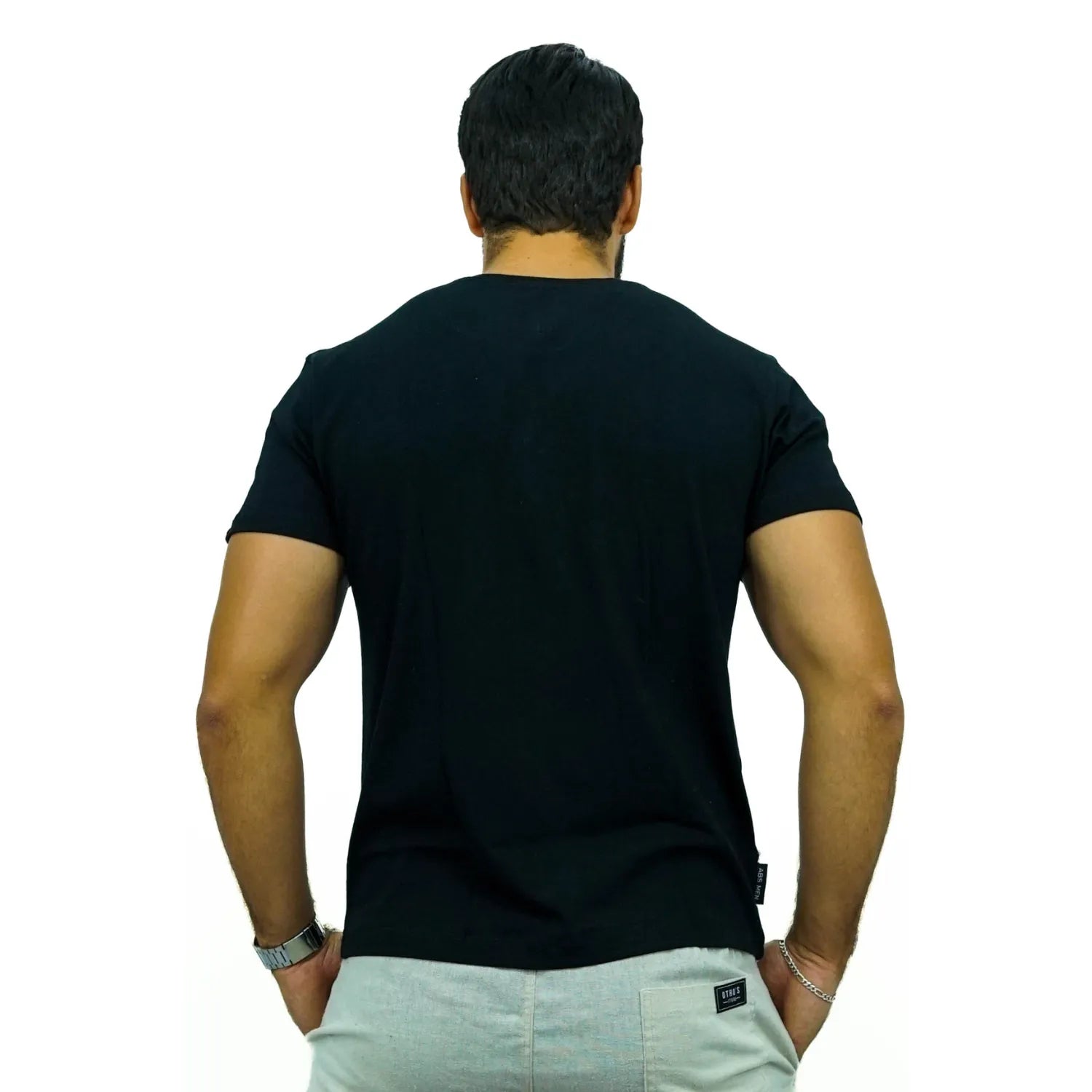 Modelo de costas usando camiseta lisa de algodão e elastano com logo bordada da Absinto Men na cor preta.