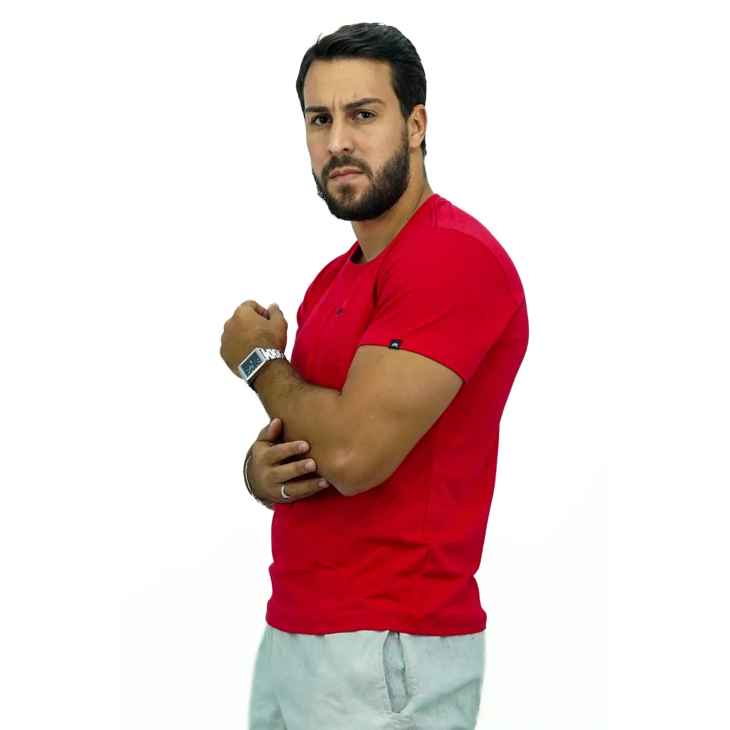 Modelo usando camiseta lisa de algodão e elastano com logo bordada na cor vermelha.