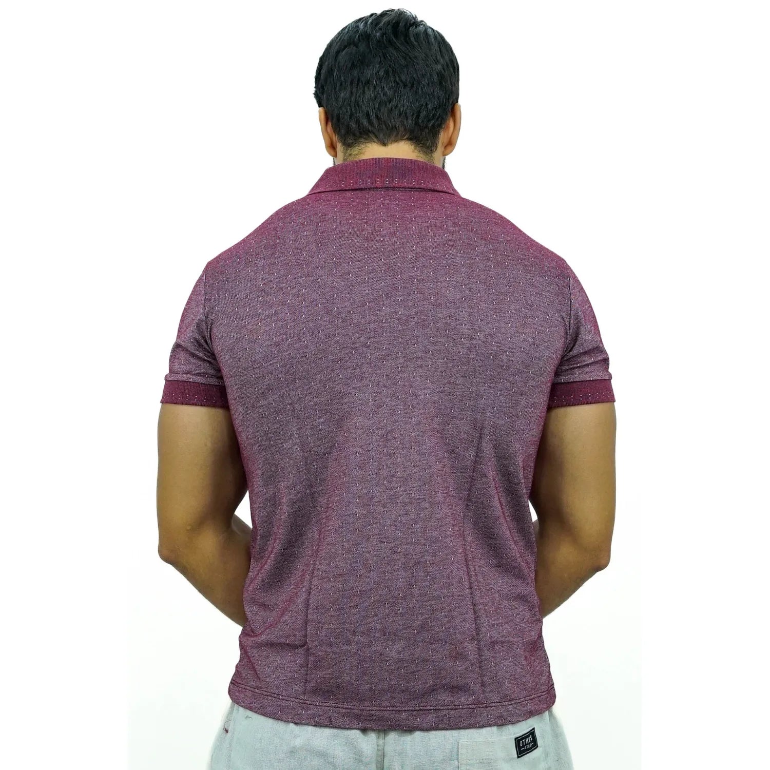 Modelo vestindo camisa gola polo maquinetada, de algodão e poliéster, na cor bordô da marca Absinto Men.