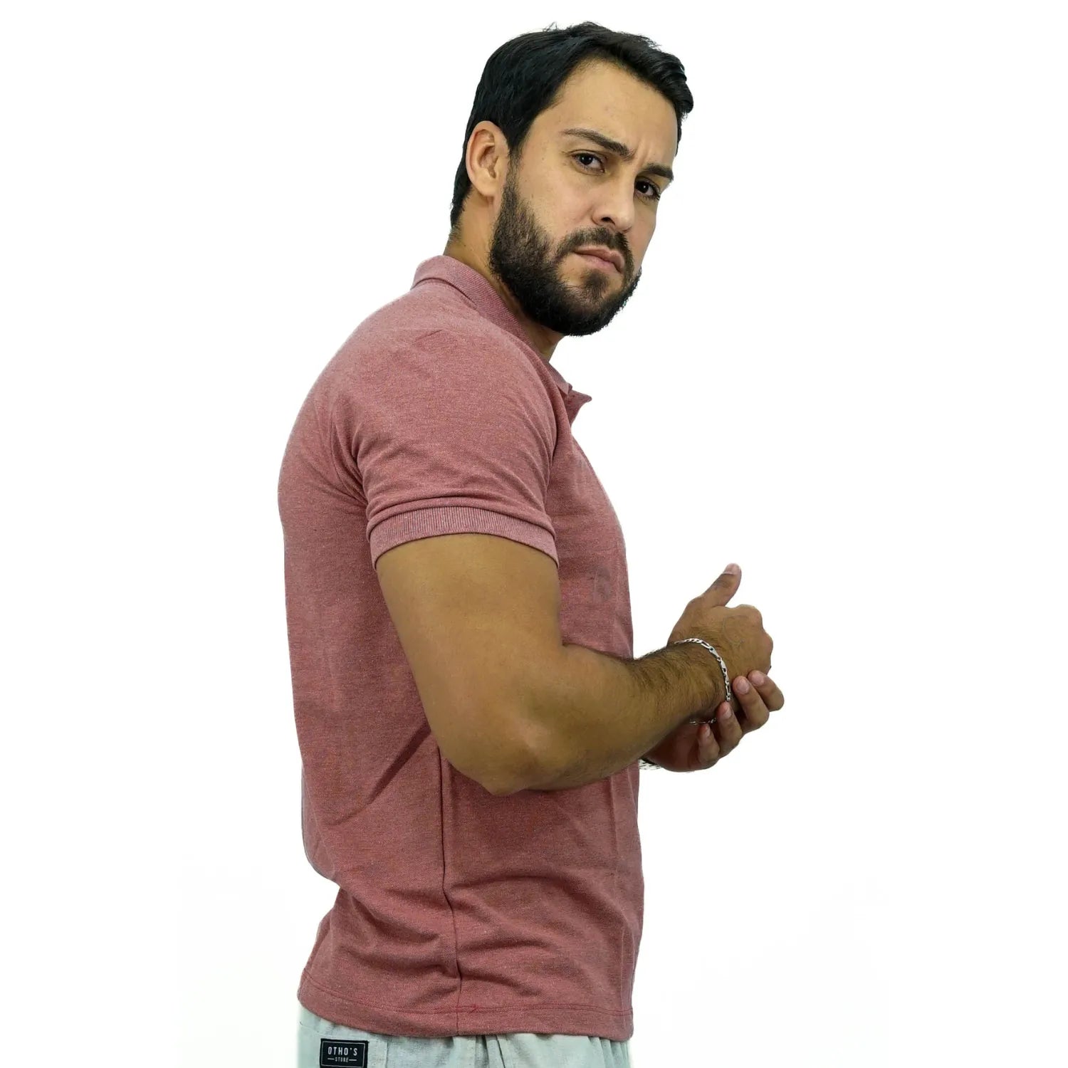 Modelo usando camisa gola polo de algodão e poliéster, lisa, na cor salmão da Absinto Men.
