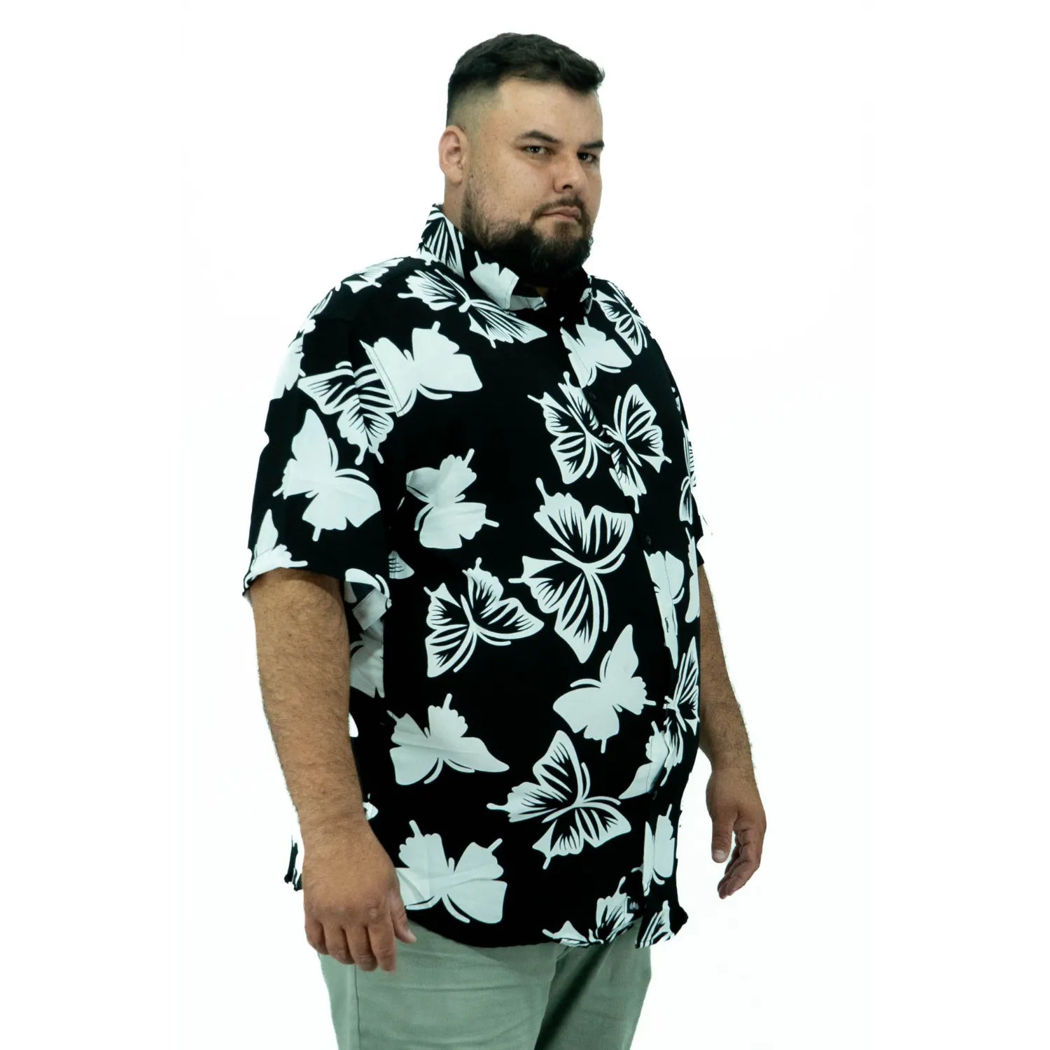 Modelo usando camisa social de viscose plus size de manga curta e com estampa de borboleta, na cor preta da Absinto Men.