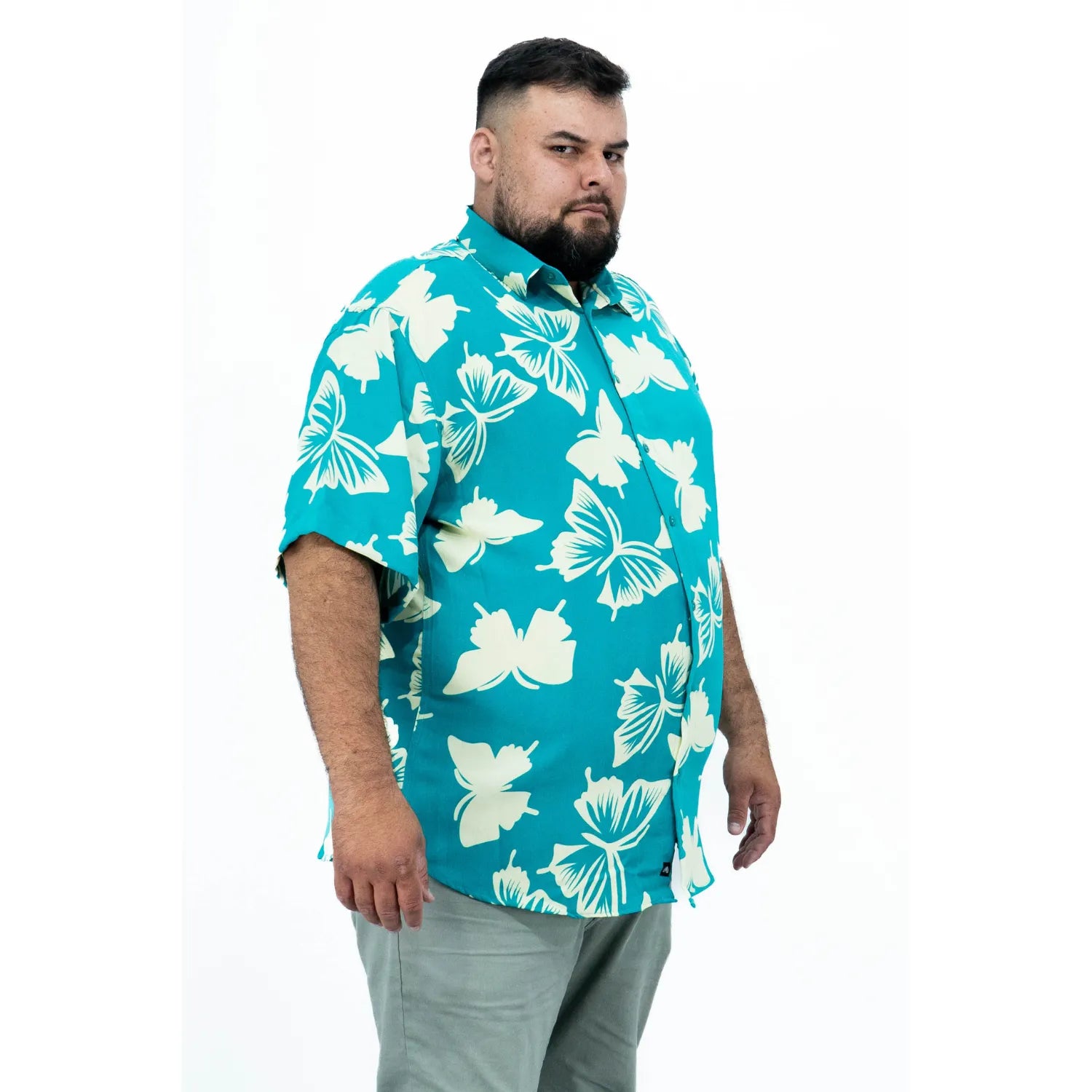 Modelo usando camisa social de viscose plus size de manga curta e com estampa de borboleta, na cor verde água da Absinto Men.