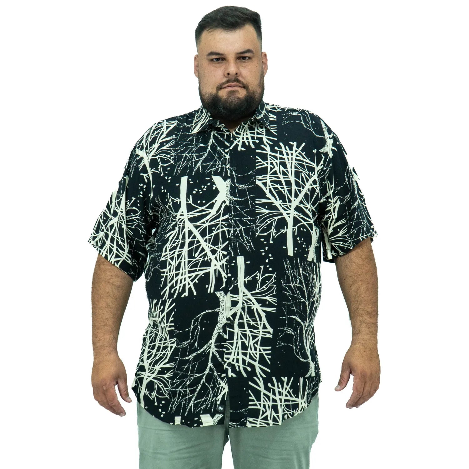 Modelo usando camisa social de viscose plus size de manga curta e com estampa de galhos na cor preta da Absinto Men.