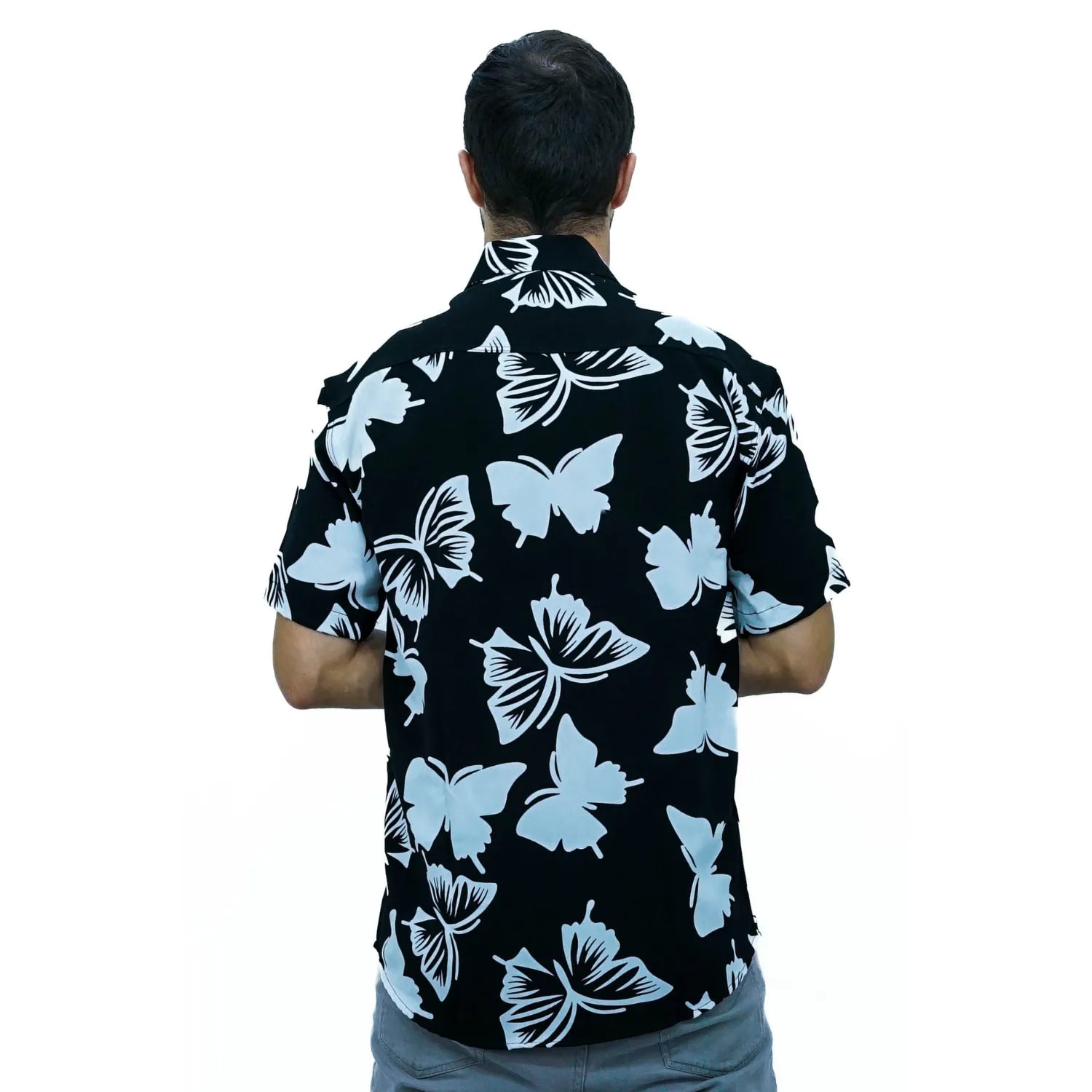 Modelo usando camisa social de viscose, de manga curta e com estampa de borboleta, na cor preta  da Absinto Men.