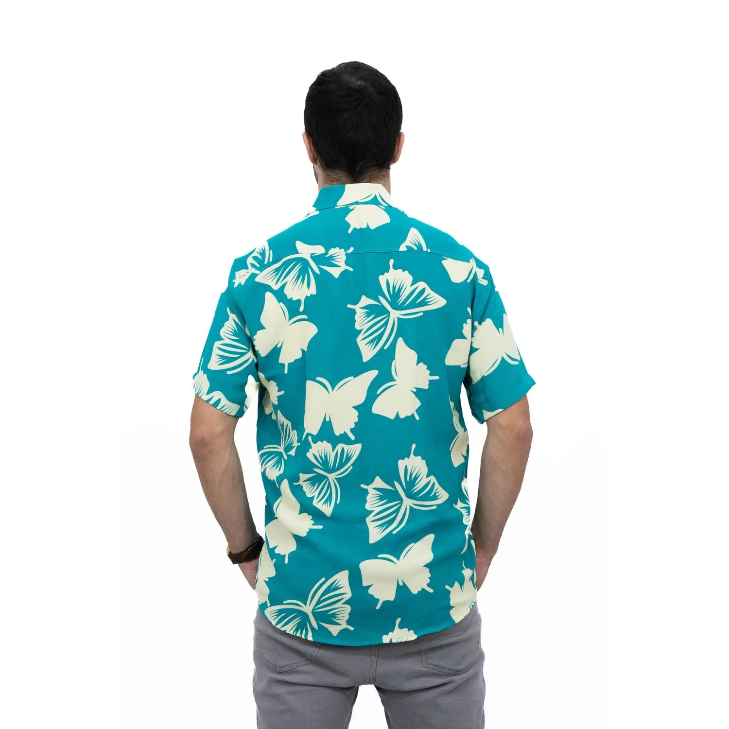 Modelo usando camisa social de viscose, de manga curta e com estampa de borboleta, na cor verde água da Absinto Men.