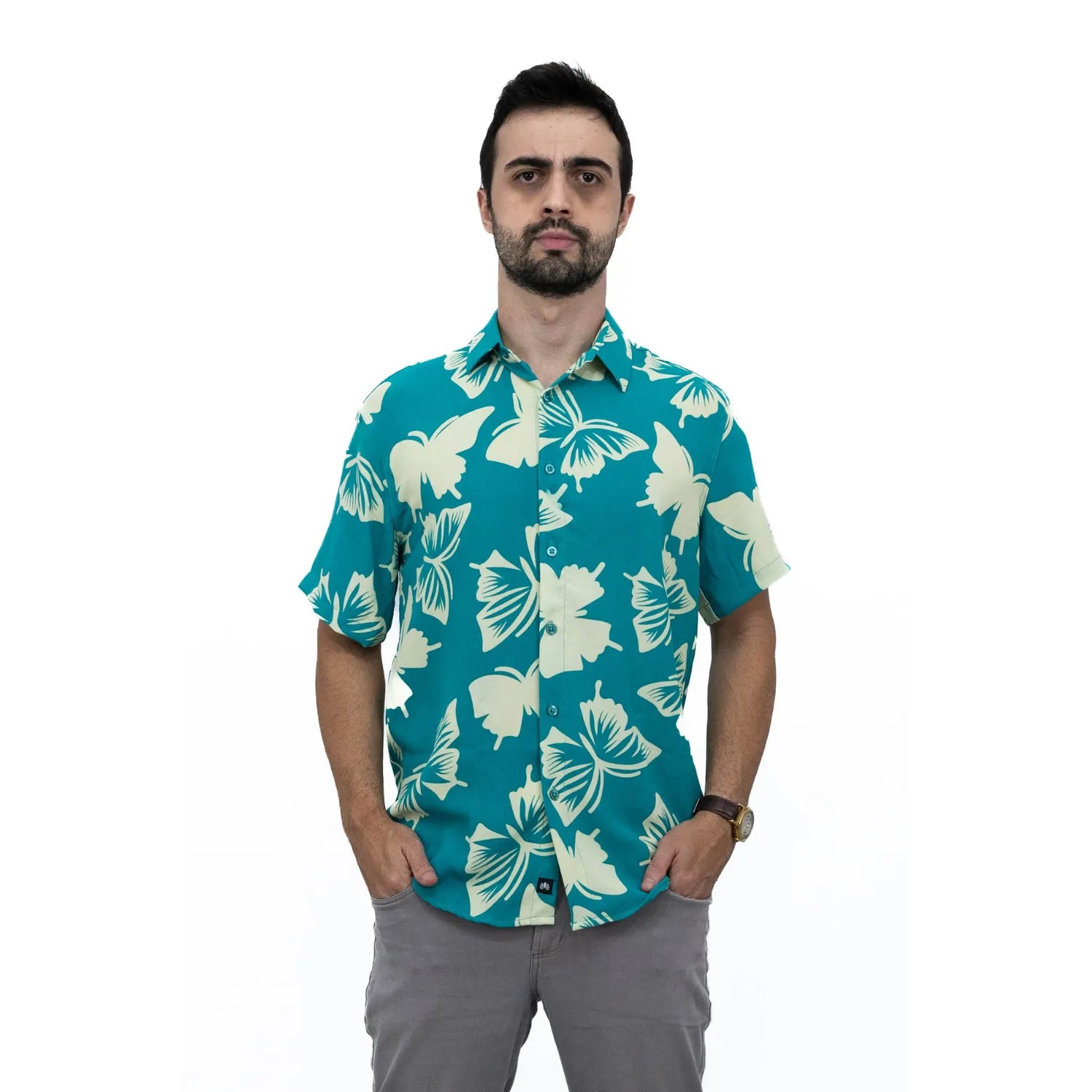 Modelo usando camisa social de viscose, de manga curta e com estampa de borboleta, na cor verde água da Absinto Men.
